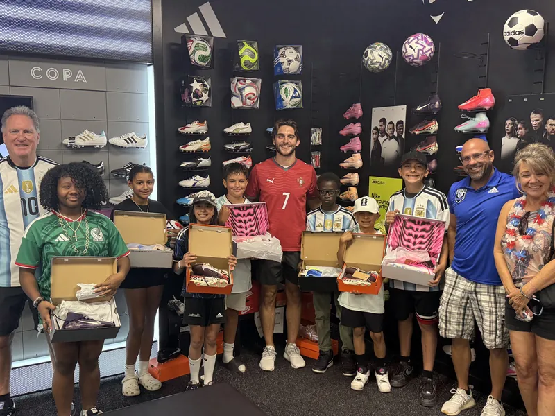 Kids holding new cleats at the soccer store